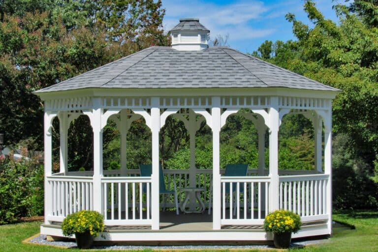Projects 18 Front View of 12x16 Vinyl Oval Gazebo with plants and in front of trees