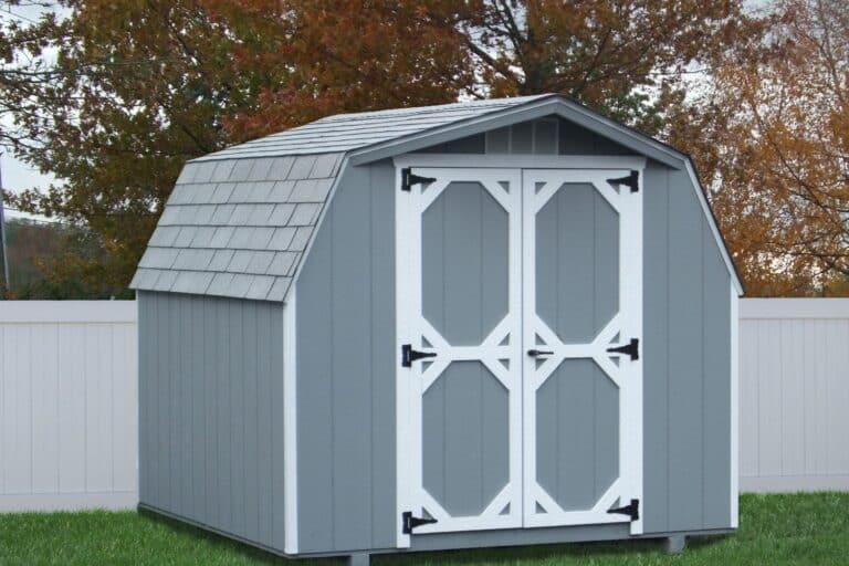 Projects 8 Blue and White Mini Barn with wood exterior in backyard against fence