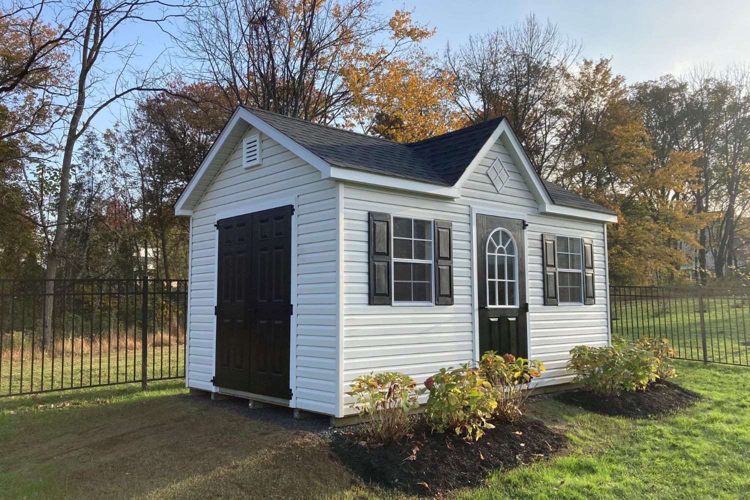 Black and white cape cod shed in backyard