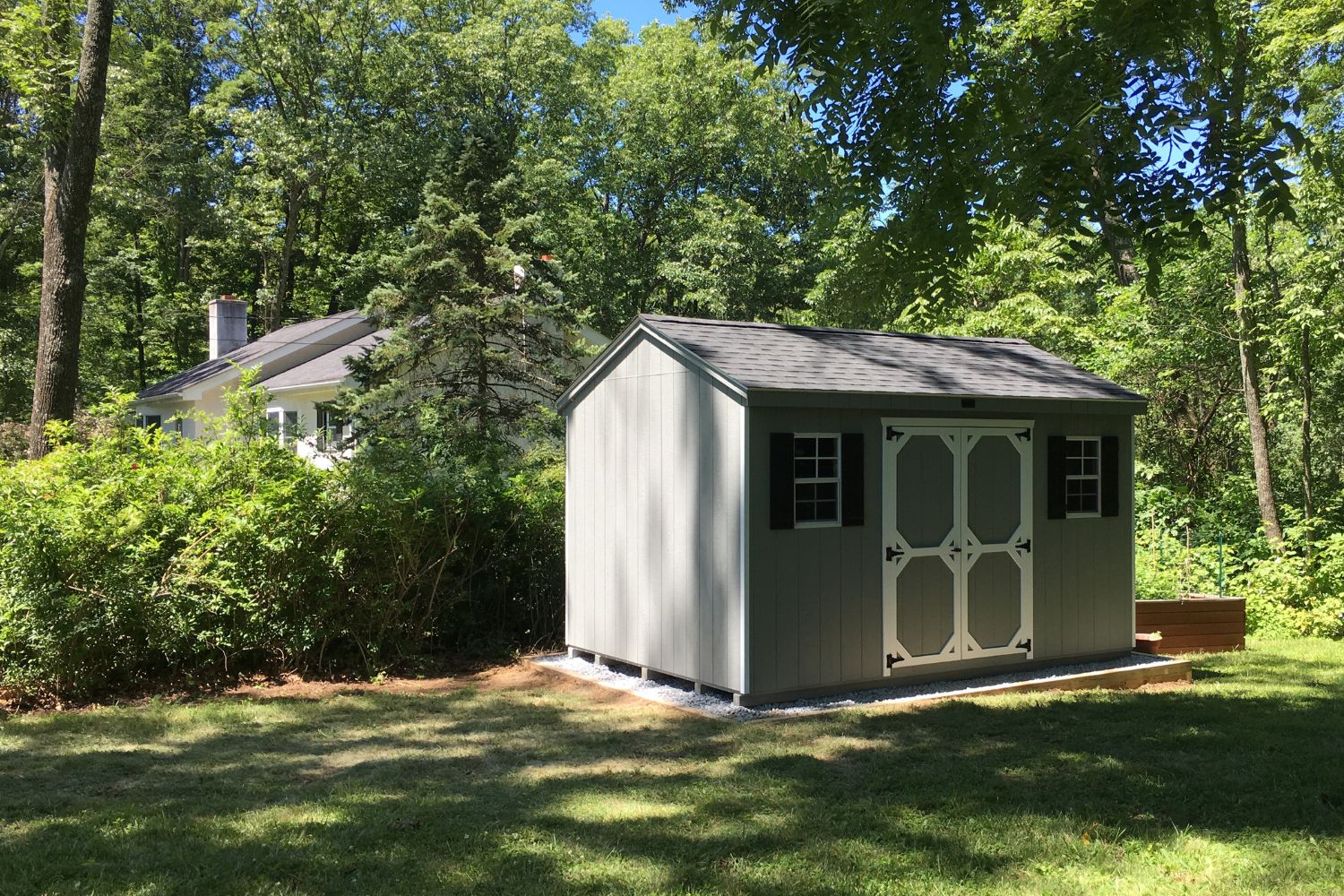 The Standard Workshop Shed 1 Gray siding standard workshop shed with white trim on double doors