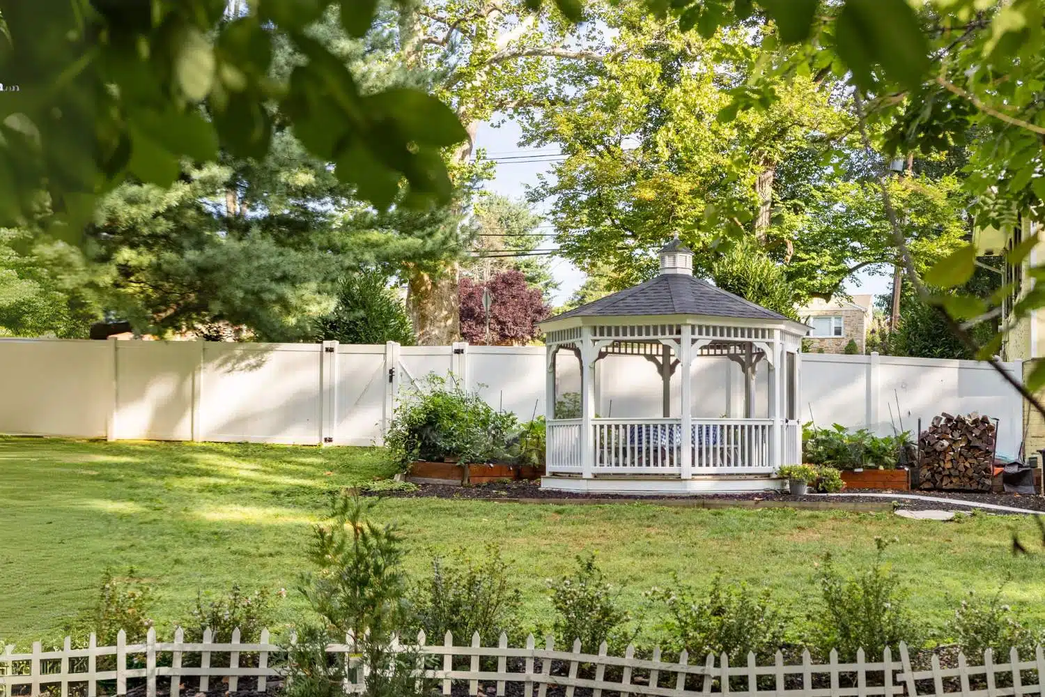 The Vinyl Octagon Gazebo in garden with white vinyl