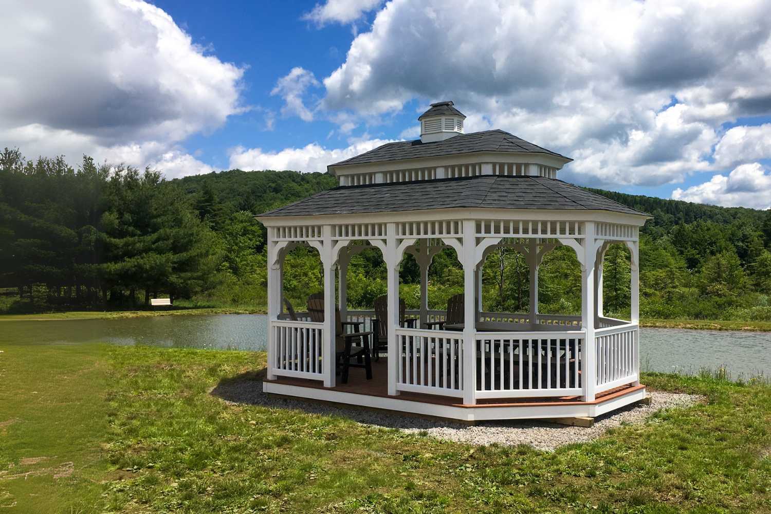 The Vinyl Oval Gazebo besides lake with seating underneath