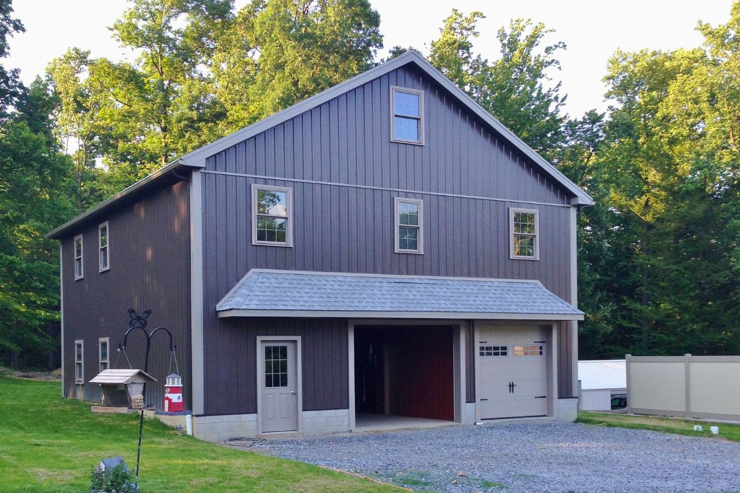 A-Frame garage with brown siding and trim by gravel driveway