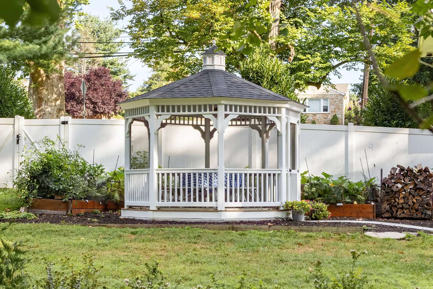 Vinyl Octagon Gazebo in garden in front of white fence